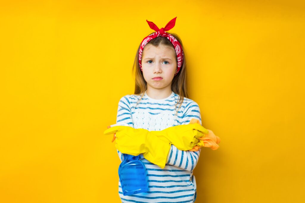 confused-little-kid-girl-housewife-9-10-apron-hold-sponge-bottle-with-washing-cleanser-detergent-doing-housework-isolated-yellow-wall-background-studio-housekeeping-concept